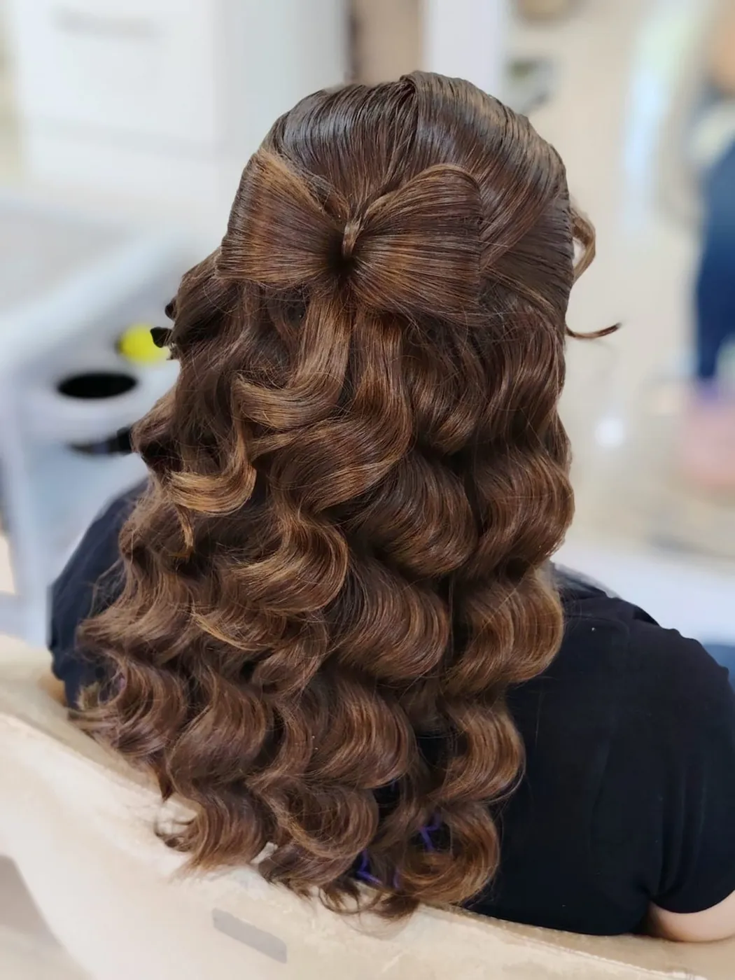 Semi recogido con moño de cabello y rulos en cabello castaño