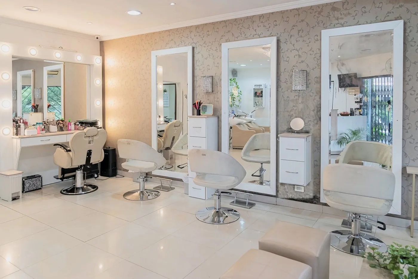 Puestos de peinado con espejos de marco blanco, apliques de cristal y tocador de maquillaje con luces