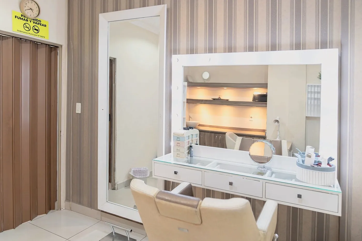 Salón privado con tocador iluminado y sillón